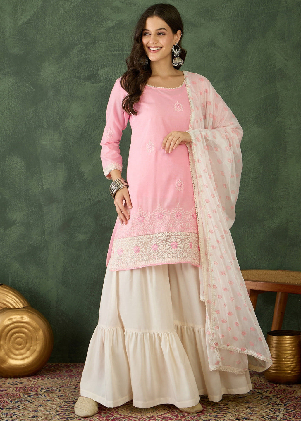 Woman wearing a pink and white traditional outfit with a green background
