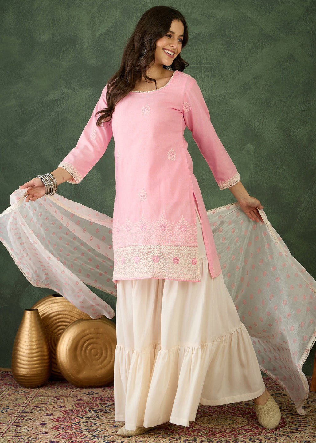 Woman wearing a pink and white traditional outfit with a green background