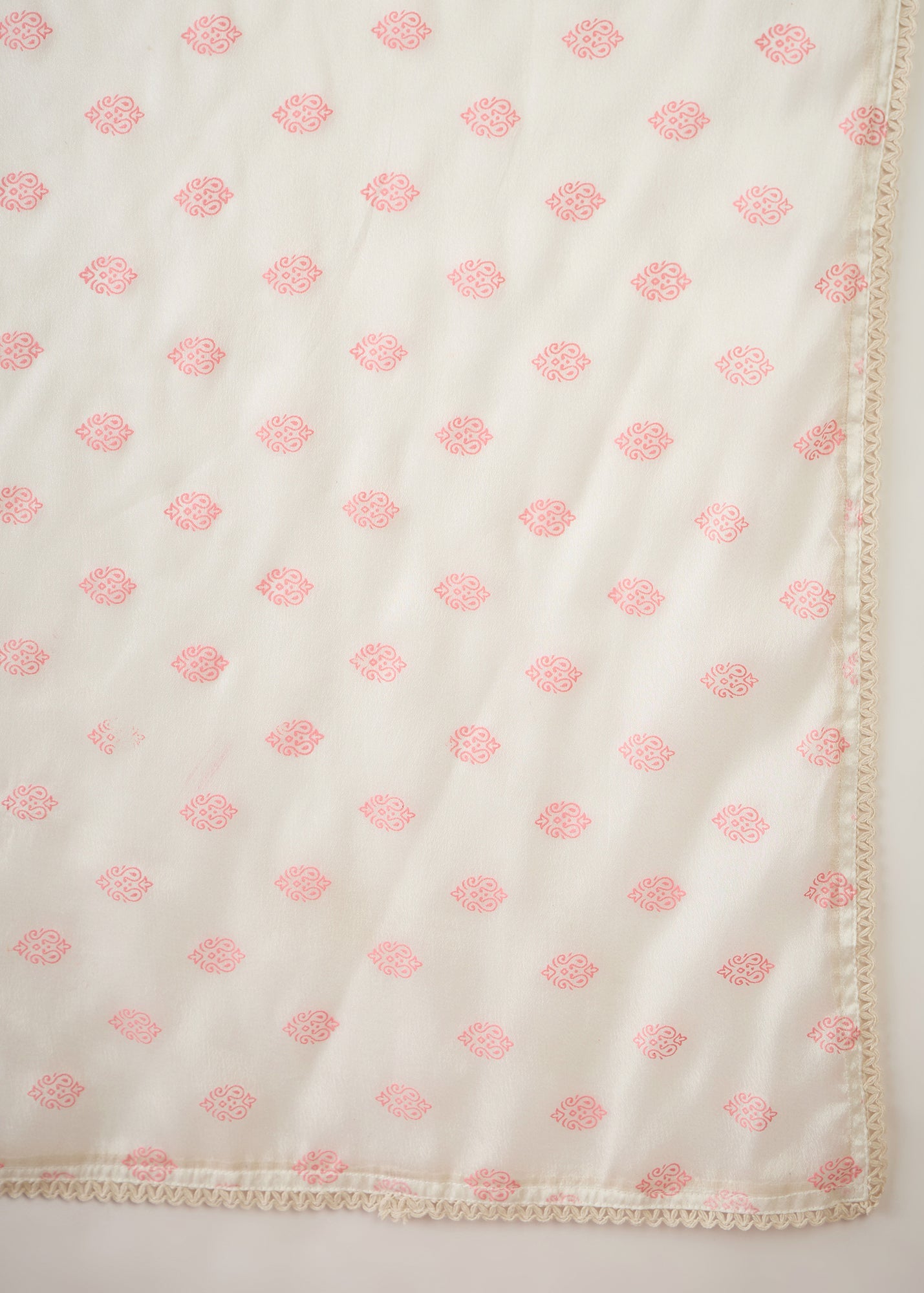 White fabric with pink floral patterns on a white background
