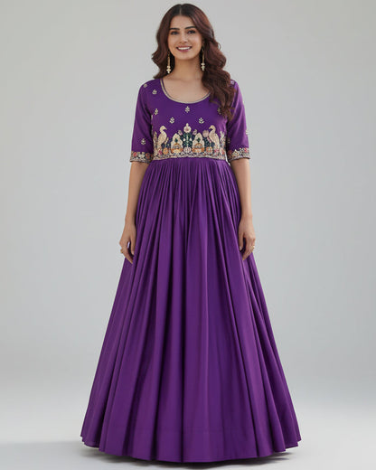 Woman in a purple gown standing in front of a building with floral decorations on the ground.