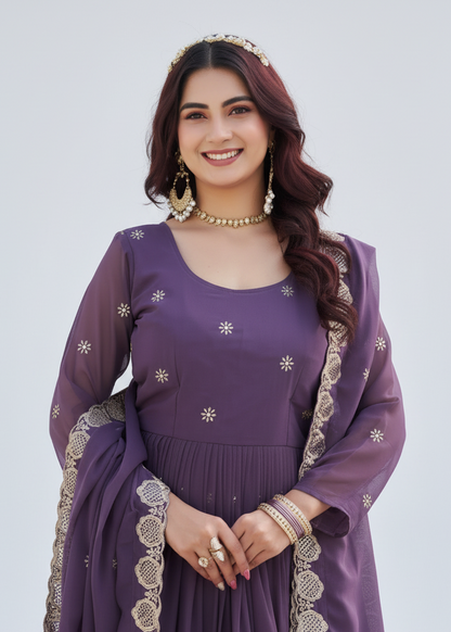 Woman wearing a purple traditional outfit with gold embroidery on a white background